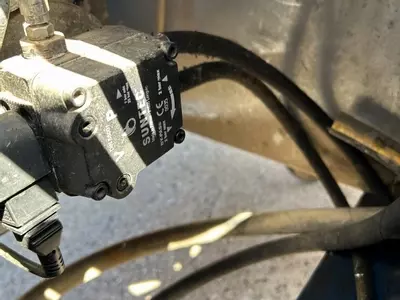 Old fuel line setup without filtration on Nilfisk DTE 500HM hot pressure washer before contaminated fuel repair in Leicester.